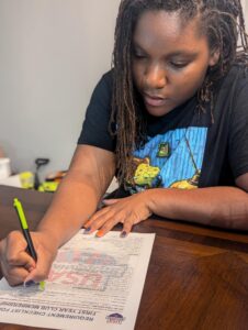 Coach Zion filling out USA Swimming paperwork to become a team